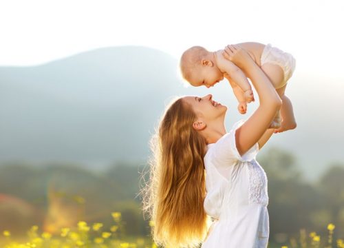 Woman and her baby outside in a field