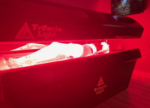 Woman in a red light therapy bed